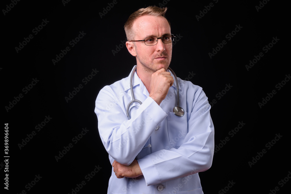 Handsome man doctor with blonde hair against black background Handsome man doctor with blonde hair against black background