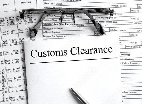 Foto Paper with text Customs Clearance on a financial tables with glasses