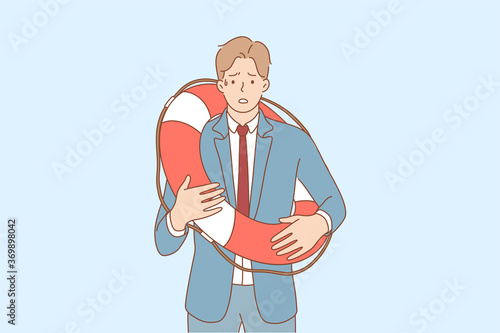 Business, rescue, shock, frustration, fear concept. Young scared frustrated stressful businessman guy clerk manager standing with lifebuoy feeling embarrassed. Financial crisis and bankruptcy saving.