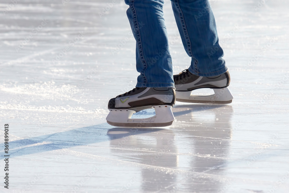 Legs of a skater on ice skating on the street ice rink. winter sport. hobbies and active recreation in sports. Legs of a skater on ice skating on the street ice rink. winter sport. hobbies and active recreation in sports.