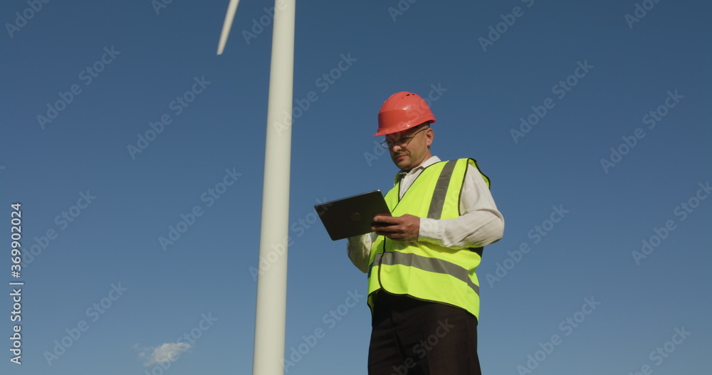 custom made wallpaper toronto digitalYoung male engineer looking at wind turbine statistics environmental energy energy windmill field worker renewable slow motion