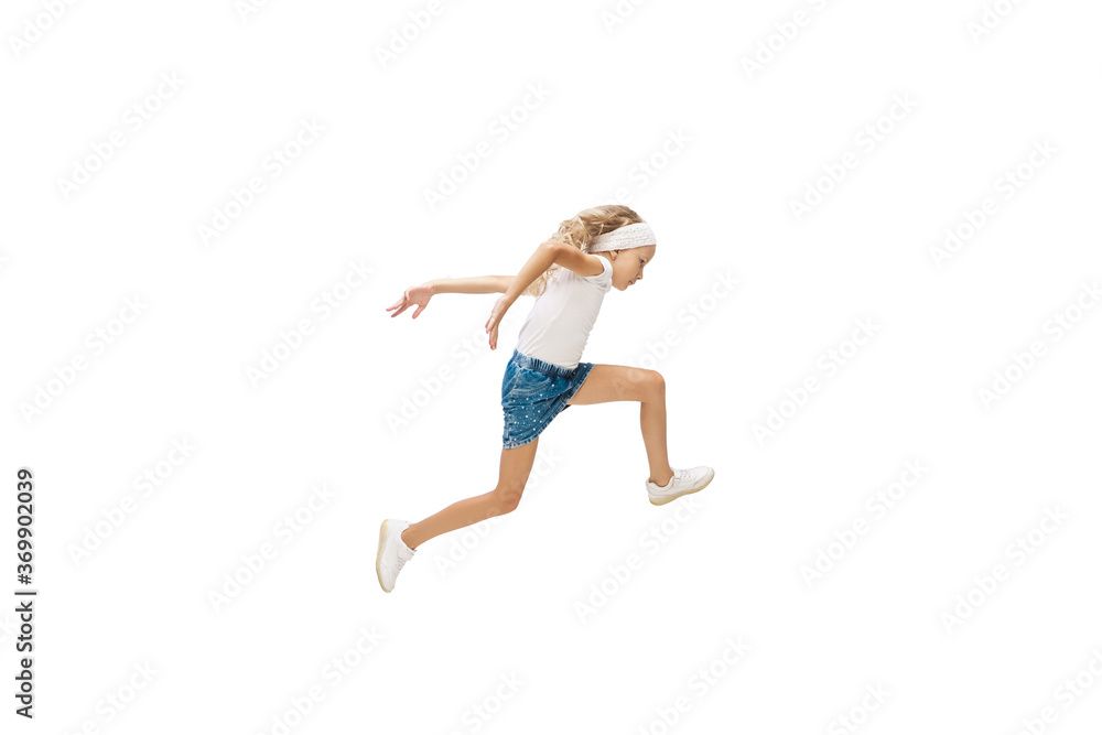 On the run. Happy kids, little and emotional caucasian girl jumping and running isolated on white background. Look happy, cheerful, sincere. Copyspace for ad. Childhood, education, happiness concept.