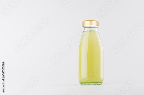 Green fruit juice in glass bottle with gold cap mock up on white background with copy space, template for packaging, advertising, design product, branding.