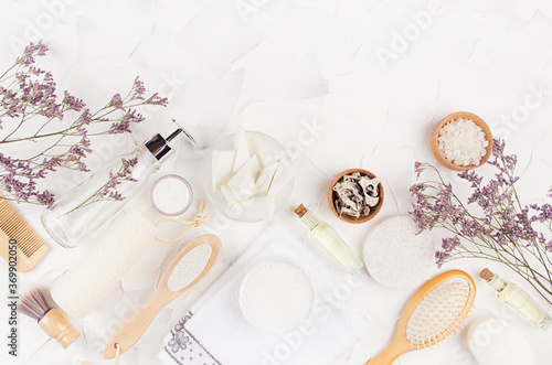Natural rustic eco beige cosmetic products and accessories for body and skin care with lavender twigs on soft light white background, border.