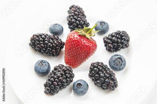 blueberries, strawberries and blackberries on a white plate