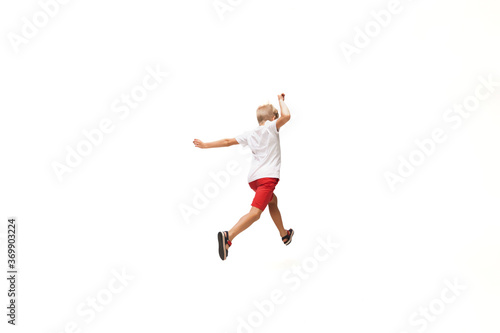 Target. Happy kids, little and emotional caucasian boy jumping and running isolated on white background. Look happy, cheerful, sincere. Copyspace for ad. Childhood, education, happiness concept.