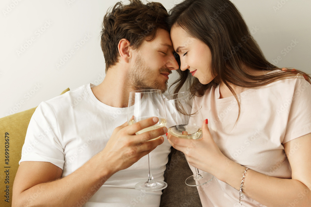 Young couple drinking white wine and relaxing at home Young couple drinking white wine and relaxing at home