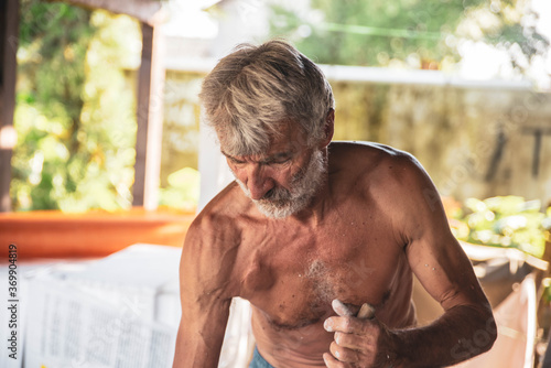 Photography An older man with a pacemaker is doing housework