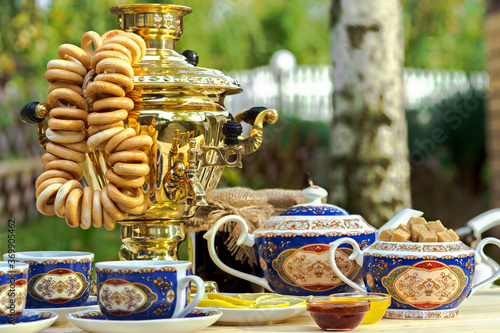 Golden samovar on the table with tea set photo