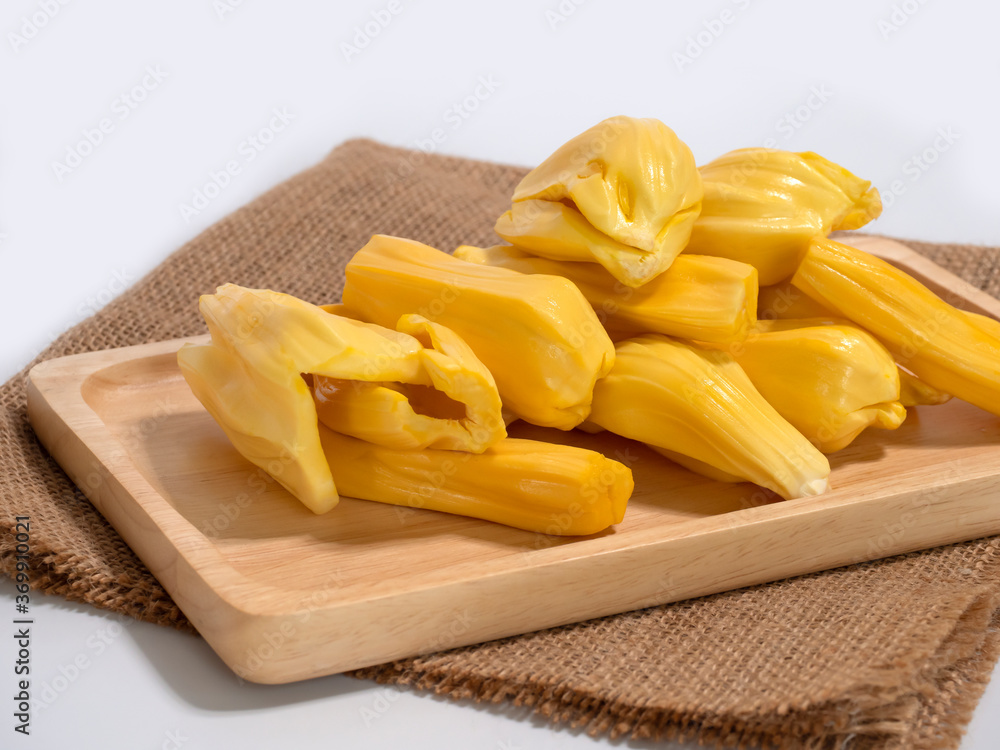 Fresh jackfruit slices on a wood plate. Fresh jackfruit slices on a wood plate.