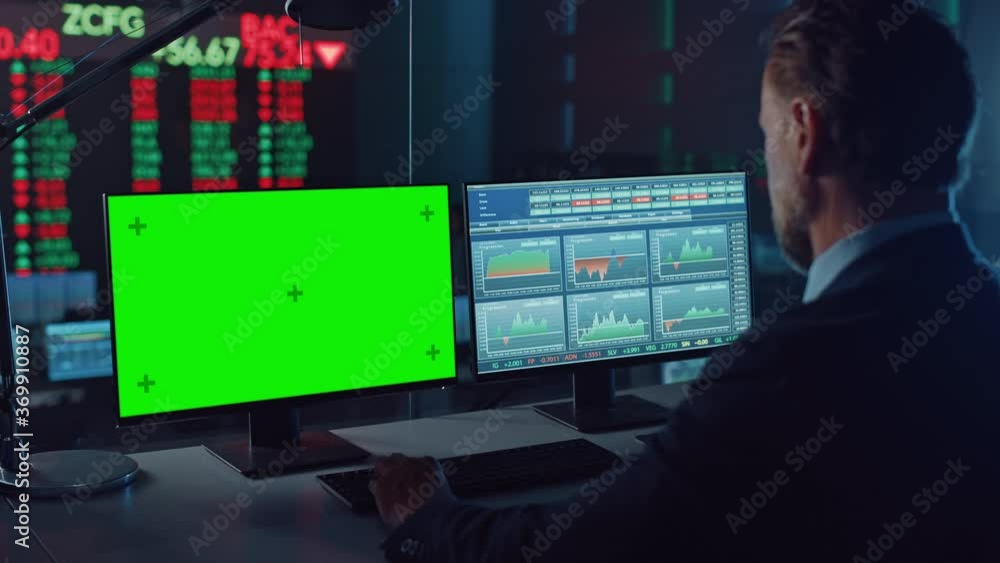 Professional Financial Data Analysts Working on a Computer with Green Screen in Modern Monitoring Office with Live Analytics Feed on a Big Digital Screen. Monitoring Room with Finance Specialists. Professional Financial Data Analysts Working on a Computer with Green Screen in Modern Monitoring Office with Live Analytics Feed on a Big Digital Screen. Monitoring Room with Finance Specialists.