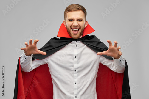 Fotografie holiday, theme party and people concept - man in halloween costume of vampire an