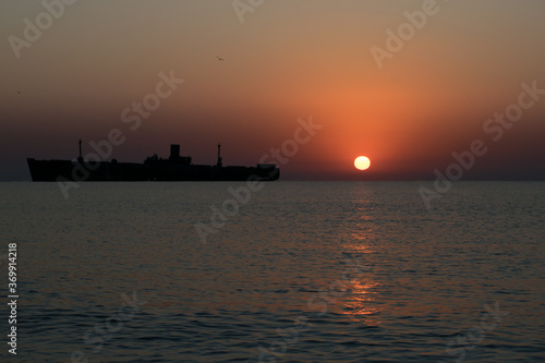 Beautiful sunrise at sea. The silhouette of an abandoned wreck in the sea. Shipwrecked © bogdan vacarciuc
