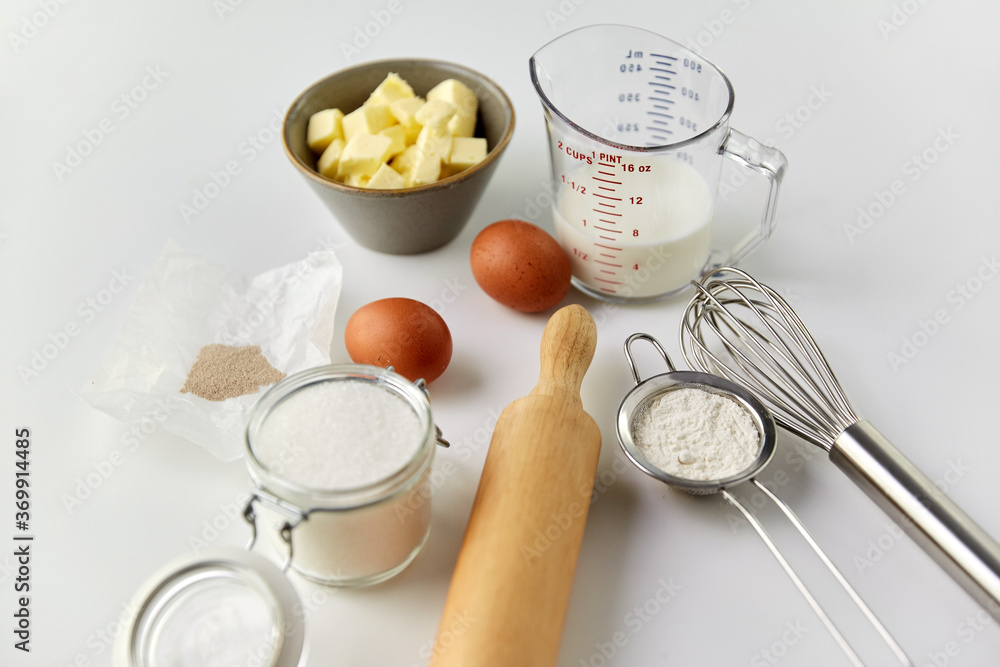 cooking food and culinary concept - rolling pin, butter, eggs, flour and cane sugar on table cooking food and culinary concept - rolling pin, butter, eggs, flour and cane sugar on table