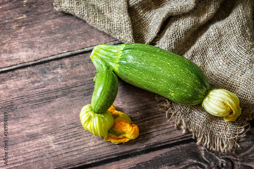 Fresh vegetable. Ugly organic twisted zucchini on wooden table. Copy space.
