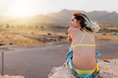 Woman in the beach wearing yellow swimsuit