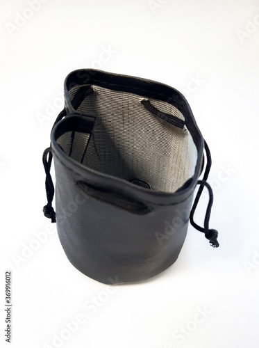 Aerial view of empty black leather pouch with drawstring closure. Vintage leather wallet case or pouch isolated on white background. Fashion accessory close up.