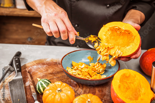 partial view of chef chopping fresh organic pumpkins