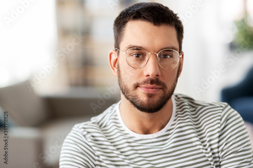 people concept - portrait of man in glasses at home