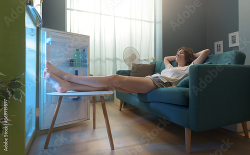 Tableau sur toile Woman cooling herself in front of the open fridge