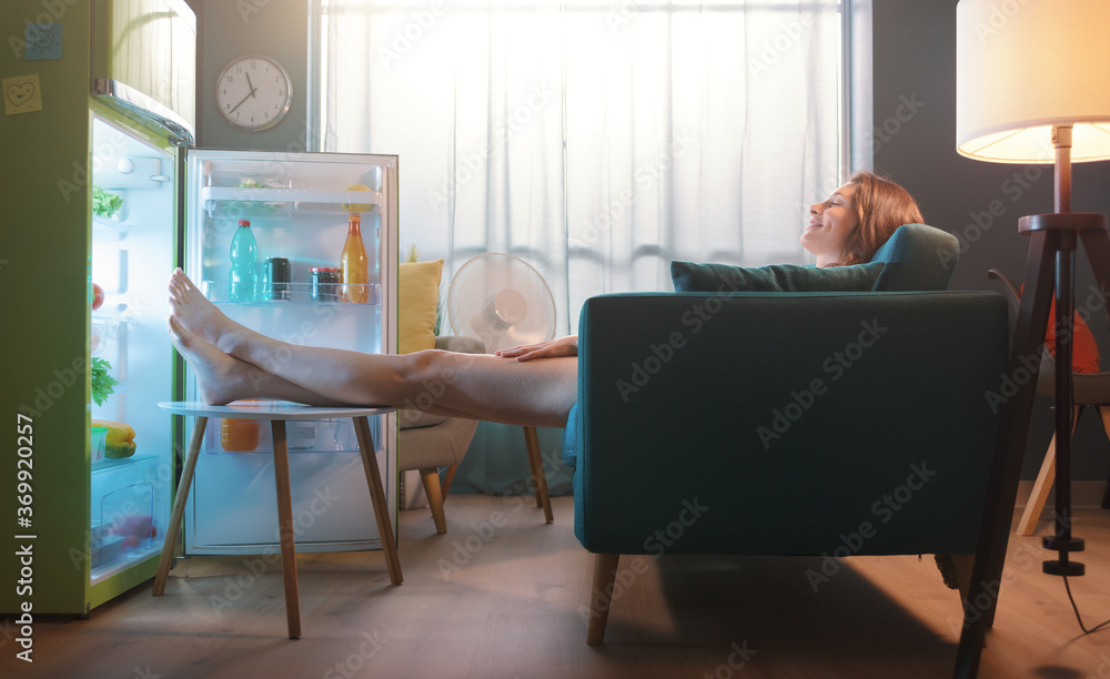 © StockPhotoPro - Woman cooling herself in front of the open fridge © StockPhotoPro - Woman cooling herself in front of the open fridge