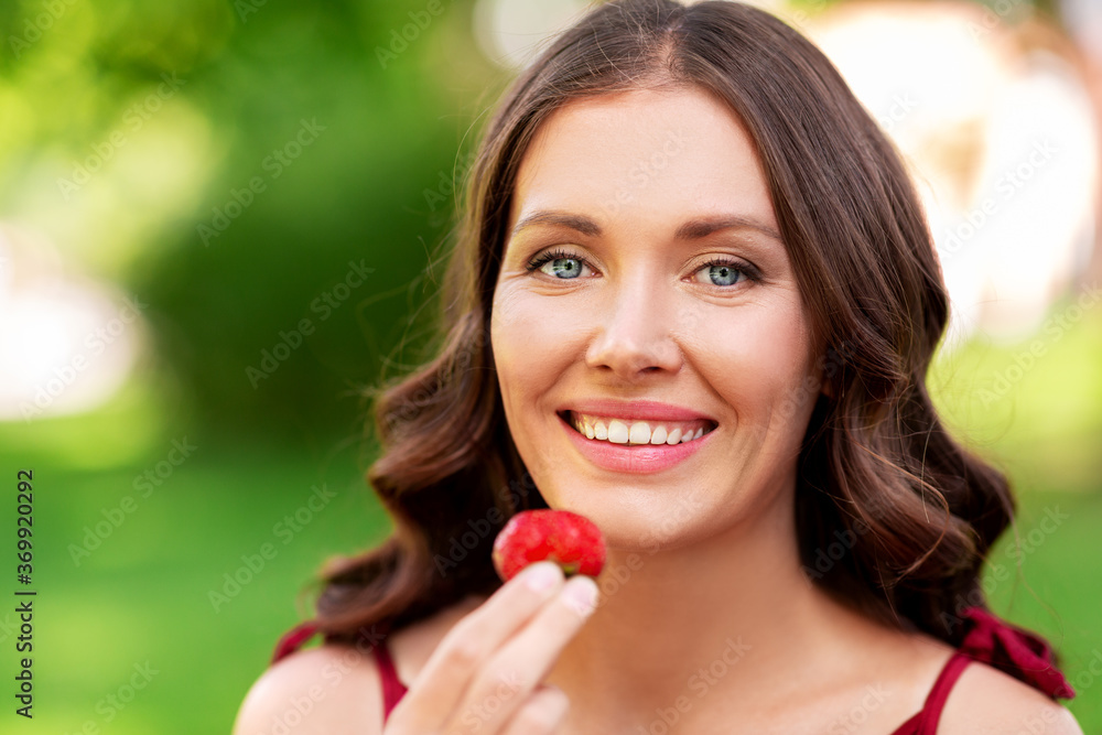 leisure and people concept - portrait of happy woman eating strawberry at summer park leisure and people concept - portrait of happy woman eating strawberry at summer park