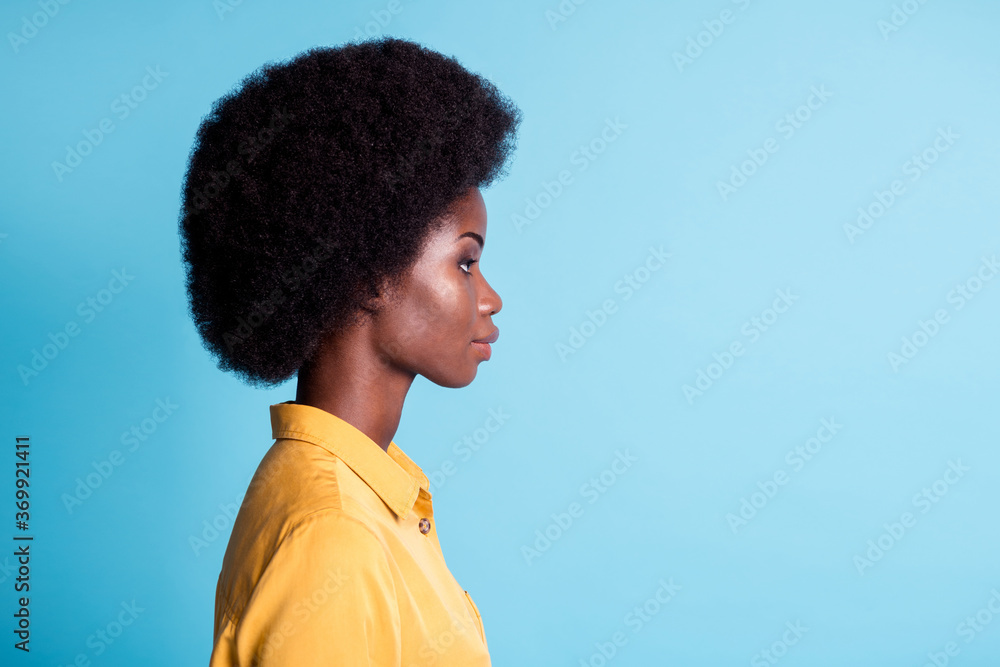 Closeup portrait side profile photo of dark skin big volume hairstyle lady calm concentrated look empty space listen colleague year report wear yellow shirt isolated blue color background Closeup portrait side profile photo of dark skin big volume hairstyle lady calm concentrated look empty space listen colleague year report wear yellow shirt isolated blue color background