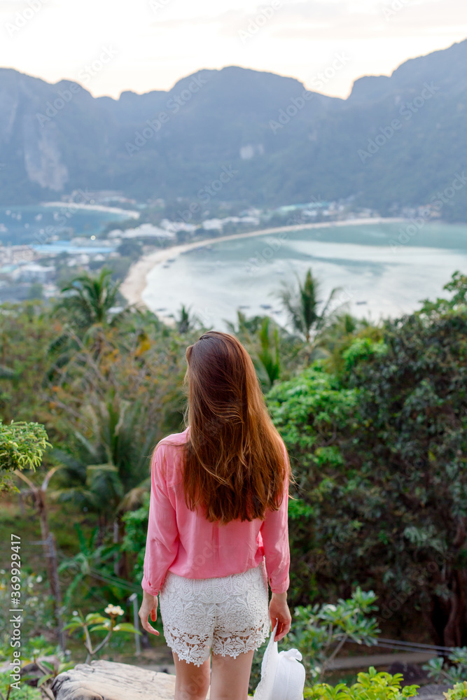 Young girl admiring beautiful view of Phi Phi Don island. View from the back.