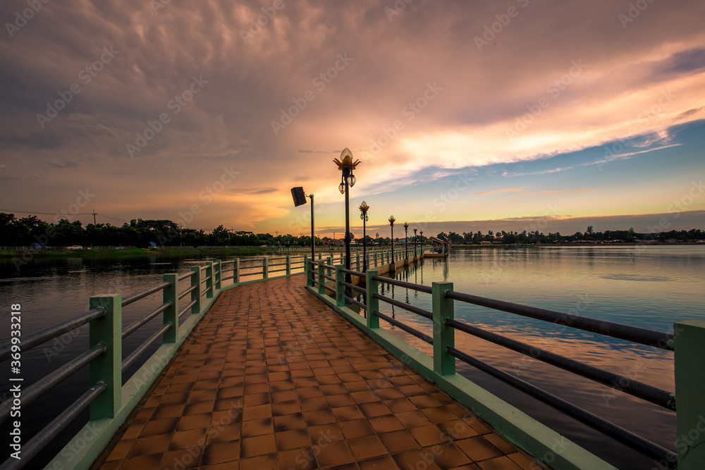 Obraz premium The blurry abstract background of the morning sky by the reservoir and there is a walkway to watch nature for exercise or rest while traveling