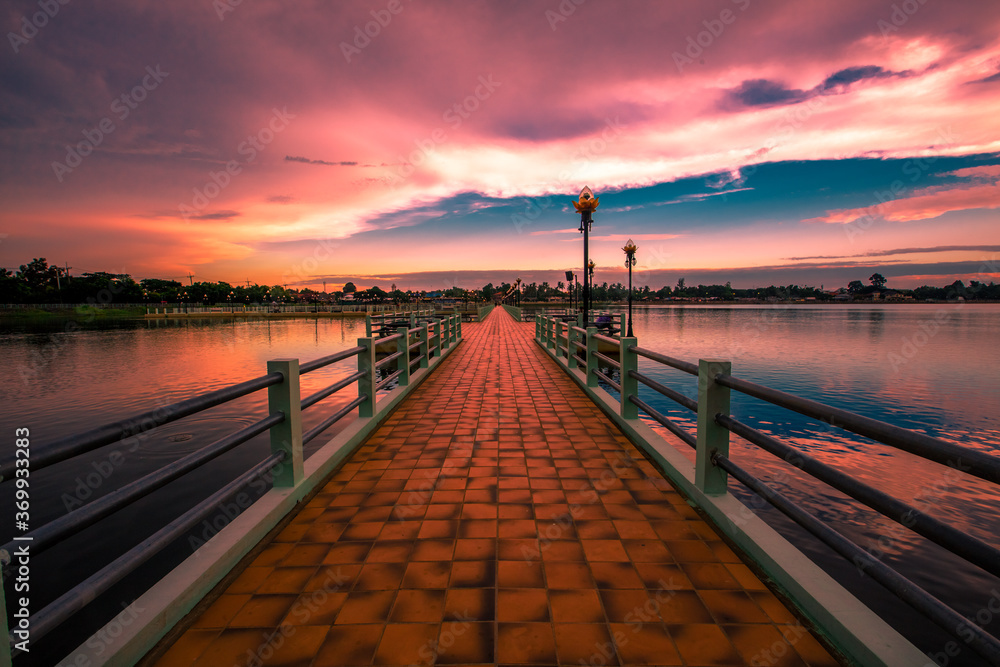 Obraz premium The blurry abstract background of the morning sky by the reservoir and there is a walkway to watch nature for exercise or rest while traveling