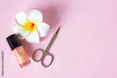 Fototapeta Naklejka Na Ścianę i Meble -   Manicure scissors nail polish and flower on pink background, manicure pedicure hygiene and body care, selective focus
