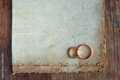 The wedding rings are on old vintage paper. Love letter. The concept of eternal love. Space for your text