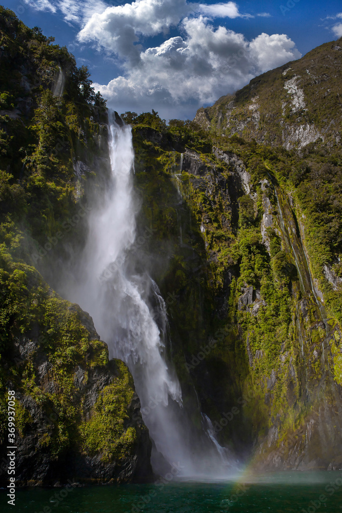 Milford Sound New Zealand. Fjordland. Coast. Mountains. Waterfall. Rainbow. Clouds. Milford Sound New Zealand. Fjordland. Coast. Mountains. Waterfall. Rainbow. Clouds.