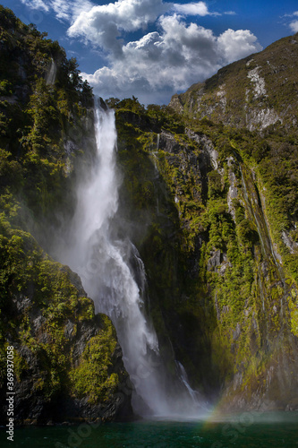 Milford Sound New Zealand. Fjordland. Coast. Mountains. Waterfall. Rainbow. Clouds. © A