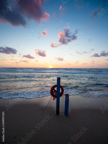 Cuadro en lienzo sunset on the shore with objects for the rescue of bathers