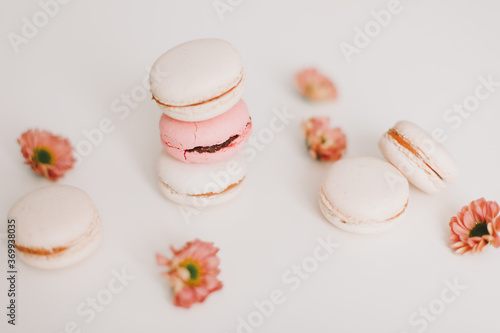 Trendy design with macaroons and flowers on white background. top view. Place for text. Birthday, wedding card