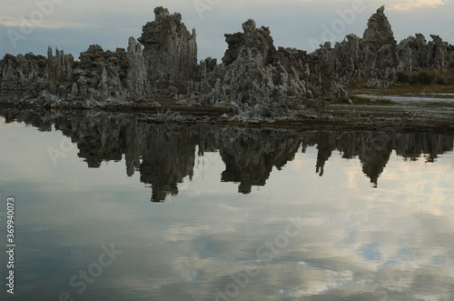 Unique mirror image if tufa formation in Mono lake, California, setting on a stromy morning and adds drama and mystery to photo, story of patterns, shapes, texture dark colors photo