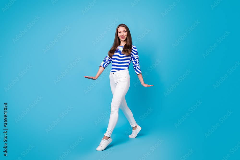 Full length body size view of her she nice-looking attractive pretty lovely cheerful cheery girl wearing casual walking isolated bright vivid shine vibrant blue color background