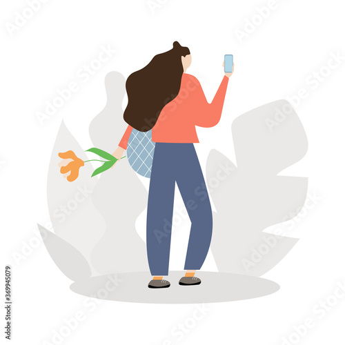 Woman stands with her back to the phone in one hand and a flower in the other. she returns from a store or date. Flat illustration.