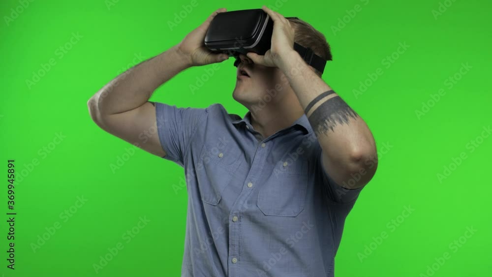 Man using VR app helmet to play simulation game, drawing. Guy watching virtual reality 3d video Man using VR app helmet to play simulation game, drawing. Guy watching virtual reality 3d video