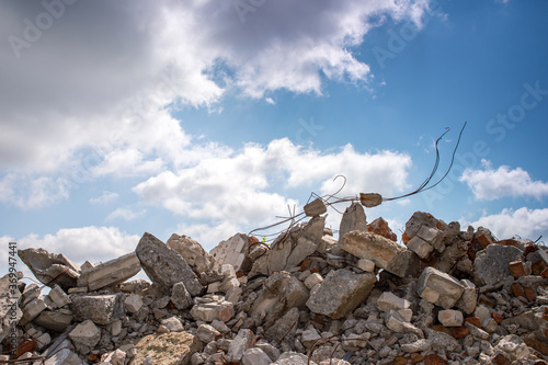 Bilde på lerret The wreckage of the remains of a building against a blue sky with gray clouds