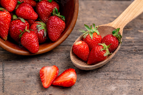 Sweet Strawberry, natural fruits. Strawberries with wooden spoon on wooden table. Food background from freshly harvested strawberries