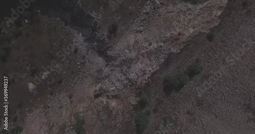 Aerial View of a Car Driving Through Rocky Valley, flat, ungraded photo