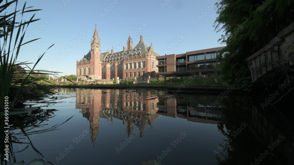 Peace Palace, one of the most visited monument in The Hague, reflected on the calm water of the rose garden and its pond, Netherlands Peace Palace, one of the most visited monument in The Hague, reflected on the calm water of the rose garden and its pond, Netherlands