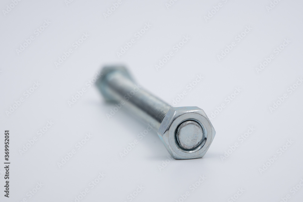 A single long bolt with a nut attached, shallow depth of field