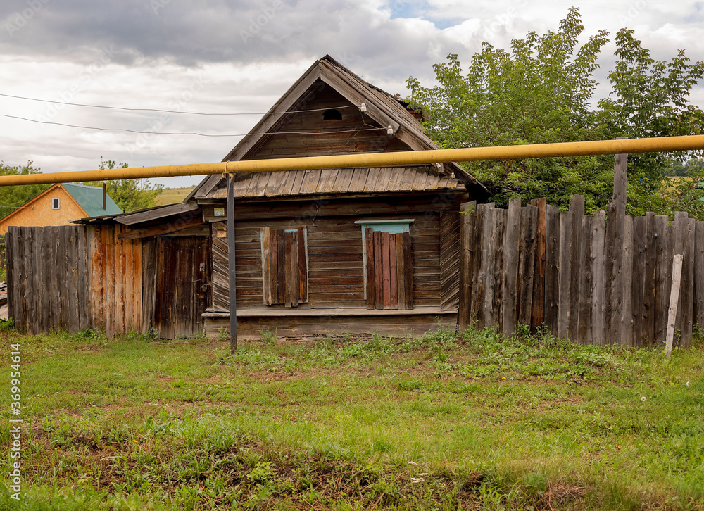 old abandoned wooden house with closed plank windows in the village. Landscape. old abandoned wooden house with closed plank windows in the village. Landscape.