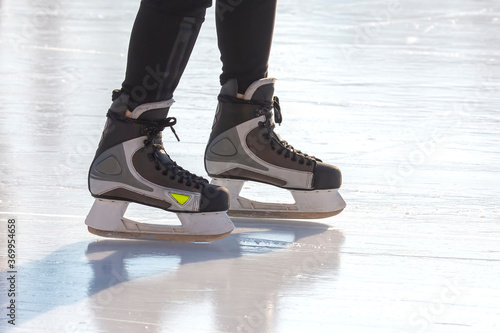 Legs of a skater on ice skating on the street ice rink. winter sport. photo