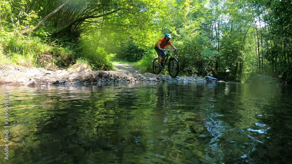 Man on bike crossing mountain river with water splashes slow motion. Man on bike crossing mountain river with water splashes slow motion.