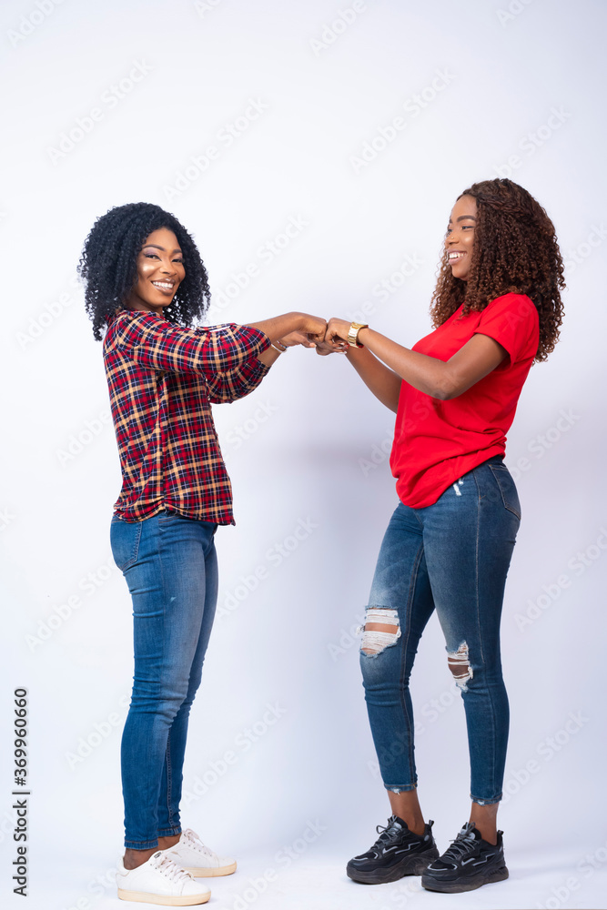 two beautiful young african ladies fist bump two beautiful young african ladies fist bump