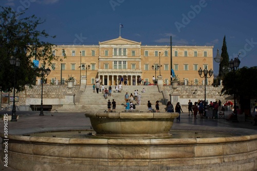 Photography marble fountain in Syntagma Square in Athens, with house of parliament behind